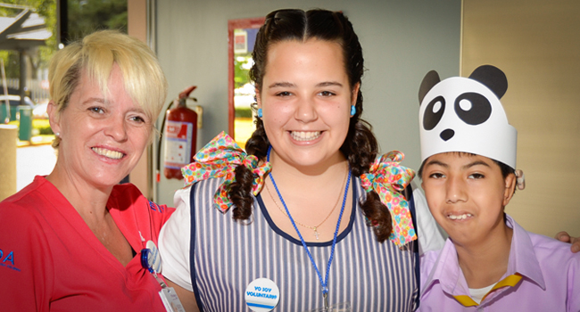 Voluntaria juvenil con voluntaria y niño